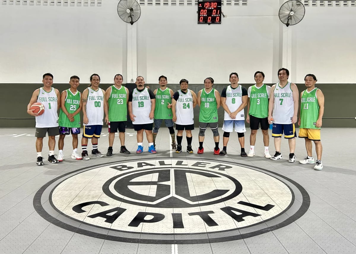 The Full Scale basketball team lined up together on court before an inter-company tournament game