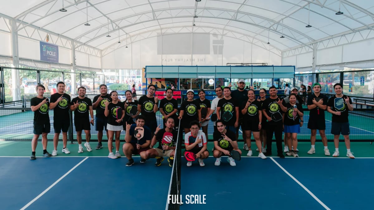 The Full Scale pickleball club, about twenty employees in matching club shirts, gathered on court after a company tournament