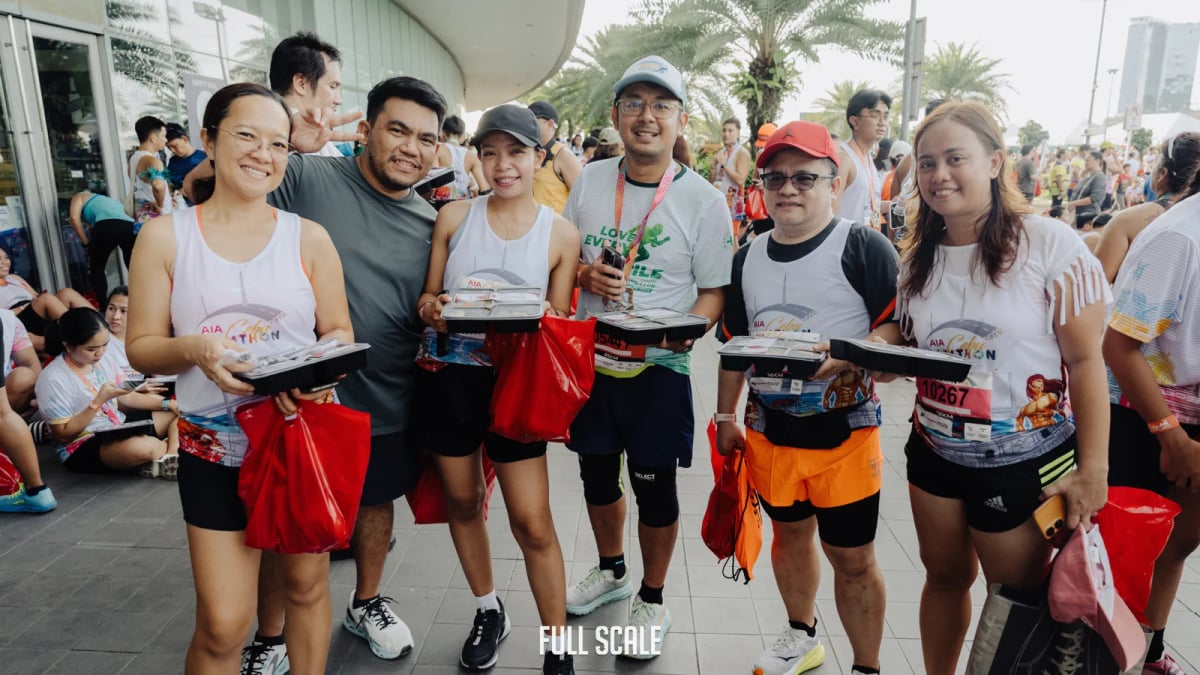 Full Scale employees together after finishing the Cebu Marathon, holding their race-day finisher kits