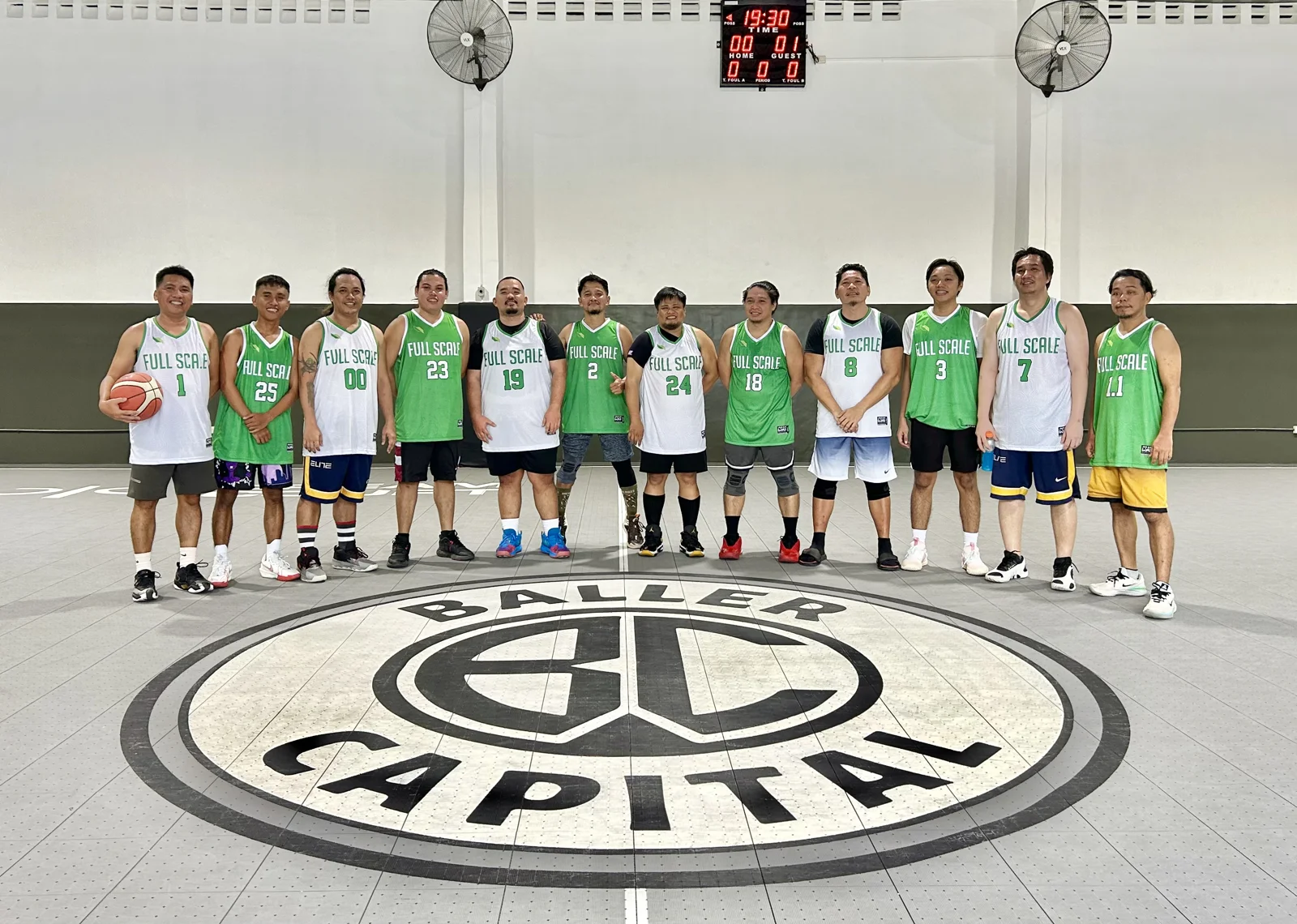 The Full Scale basketball team lined up together on court before an inter-company tournament game