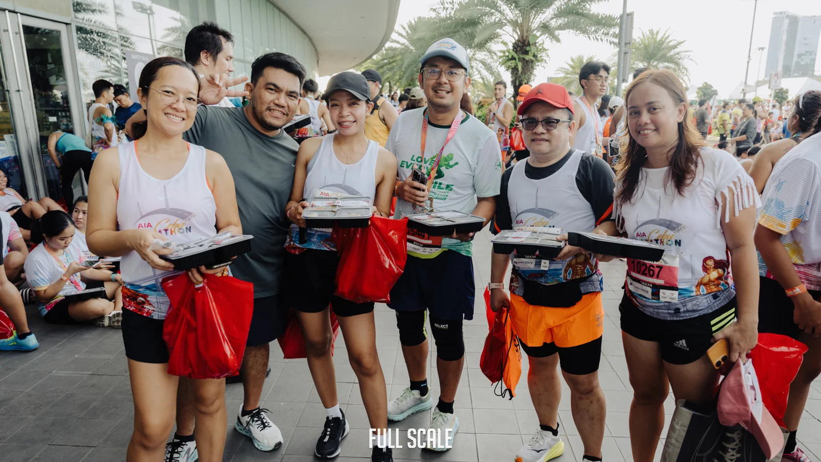Full Scale employees together after finishing the Cebu Marathon, holding their race-day finisher kits